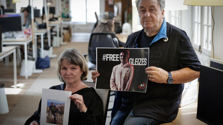 French sports journalist Christophe Gleizes' mother Sylvie Godard and his stepfather Francis Godard pose during a photo session.
