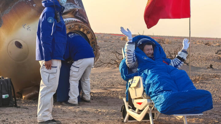 Astronaut Wang Jie of Shenzhou-20 crew waves outside the return capsule of the Shenzhou-21 crewed spacecraft which landed at the Dongfeng landing site in Inner Mongolia Autonomous Region, China November 14, 2025.
