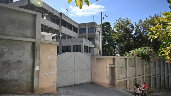 In this file photo, people walk by the entrance of the Congregation of Sisters of Saint Anne in Port-au-Prince, January 22, 2024.