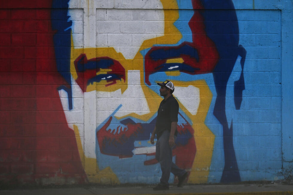 Un homme passe devant une fresque à l'effigie du président vénézuélien Nicolas Maduro, le 3 janvier 2026.