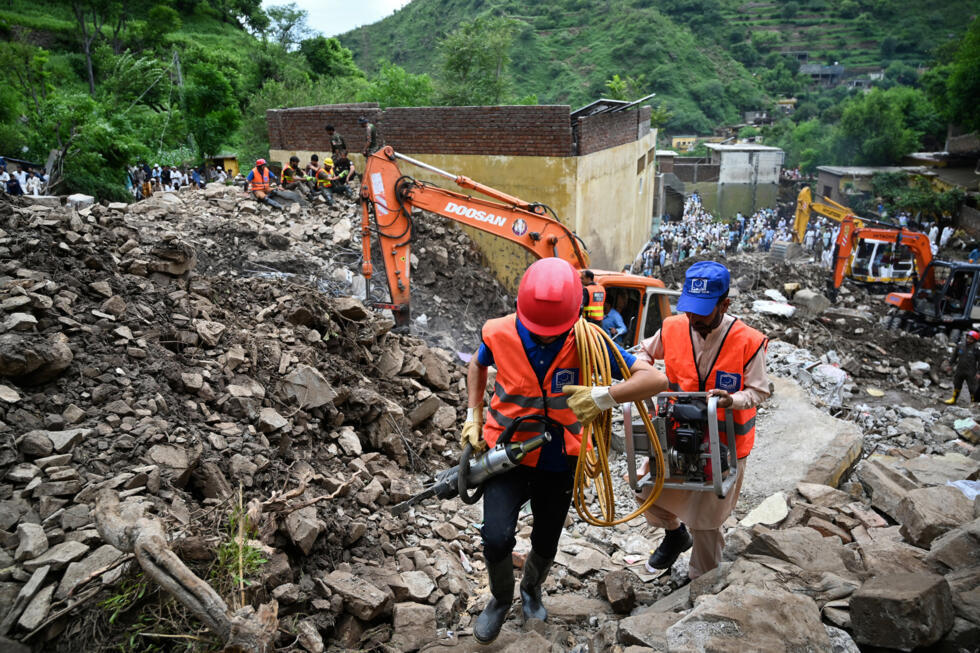 Des secouristes utilisent des pelleteuses pour dégager les décombres des maisons effondrées et rechercher des victimes dans les débris, à Dalori, dans la province montagneuse de Khyber Pakhtunkhwa, le