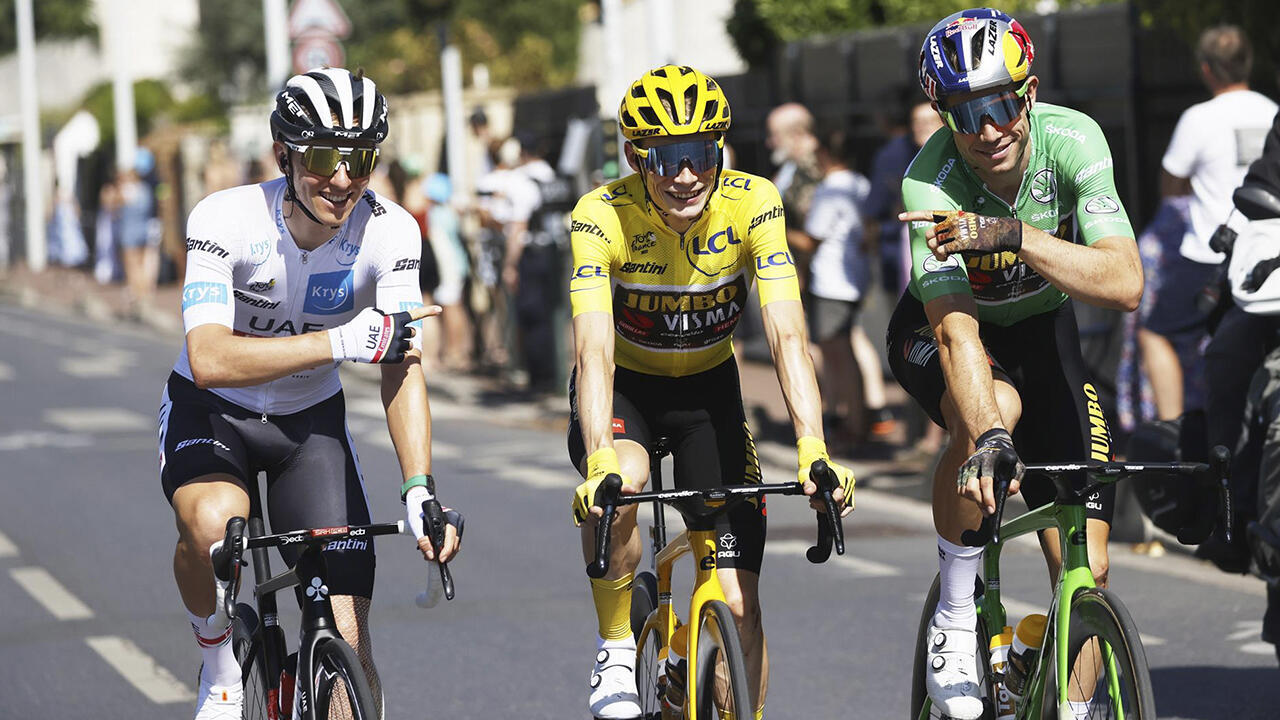 Tadej Pogacar y Wout Van Aert, de blanco y verde respectivamente, celebran a Jonas Vingegaard como nuevo campeón del Tour de Francia, París, 24 de julio, 2022.