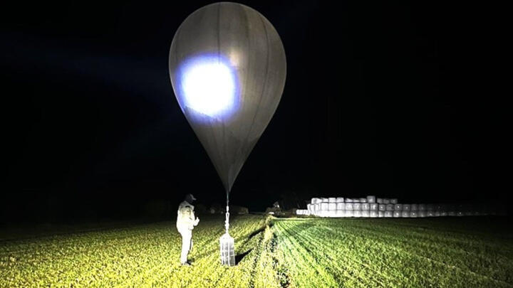 An undated photo released by Lithuanian border guards shows a police officer inspecting a balloon.