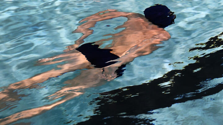 A boy swims at the new swimming pool of Chateauneuf-du-Faou, western France, as part of a visit on the theme of the Olympic and Paralympic Games preparation in Plougastel-Daoulas, western France on January 28, 2022. 