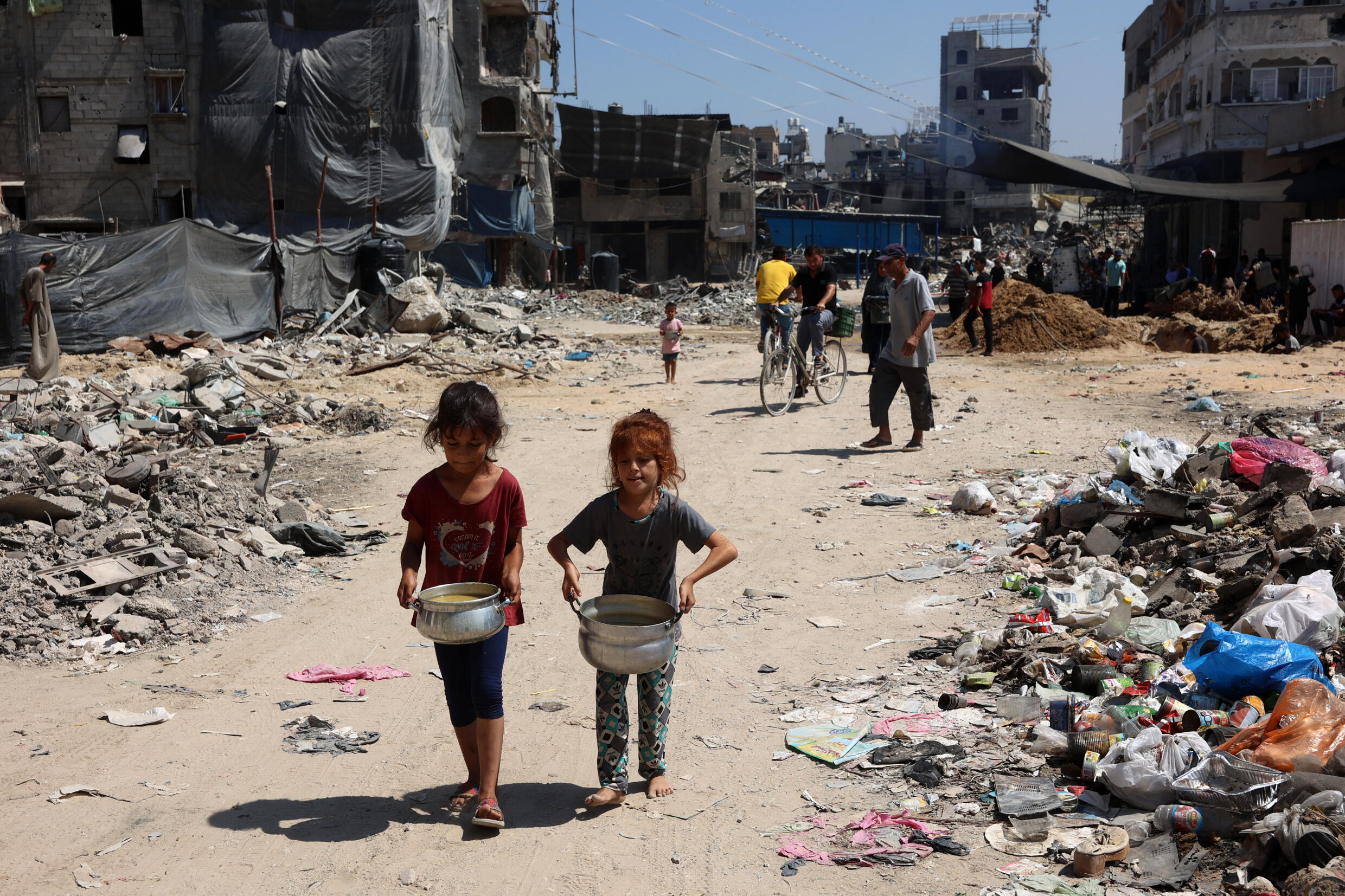 Des fillettes palestiniennes après une distribution de nourriture dans le camp de réfugiés de Jabalia, dans le nord de la bande de Gaza, le 21 août 2024