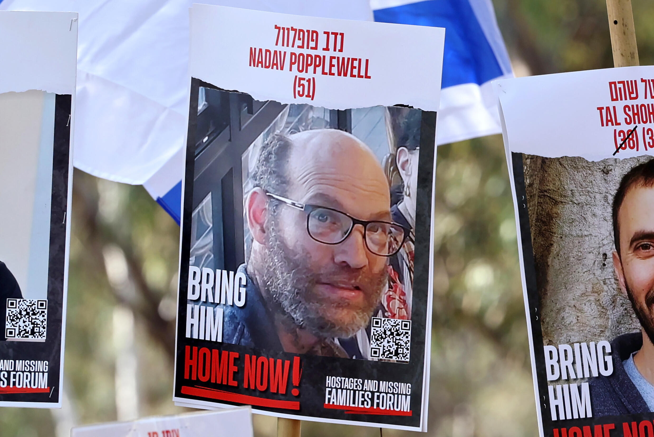 Une photo de l'otage israélien Nadav Popplewell, dont la mort a été annoncée par l'armée, brandie par des proches le 28 février 2024 près du site du festival de musique Supernova dans le sud d'Israël