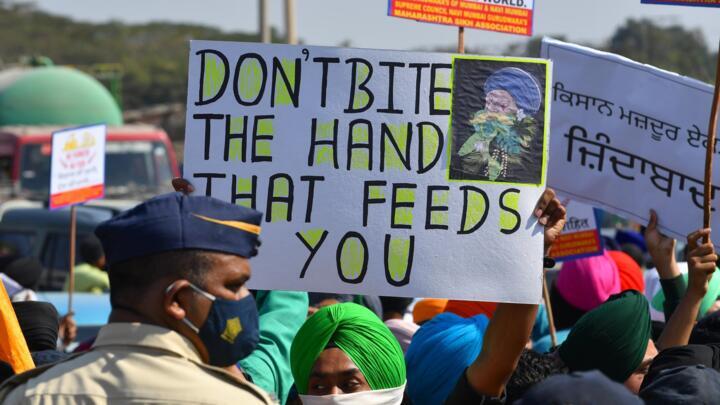 A policeman stands in front of protesters during a nationwide strike called by farmers in Mumbai, India, on December 8, 2020.