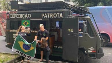 Déborah, Guilherme y Amabile izan la bandera cada mañana delante de su caravana “patriótica”.