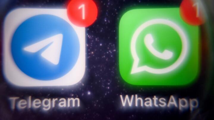 This photograph taken on March 23, 2022 shows the mobile messaging and call service Telegram logo and US instant messaging software Whatsapp logo on a smartphone screen in Moscow.