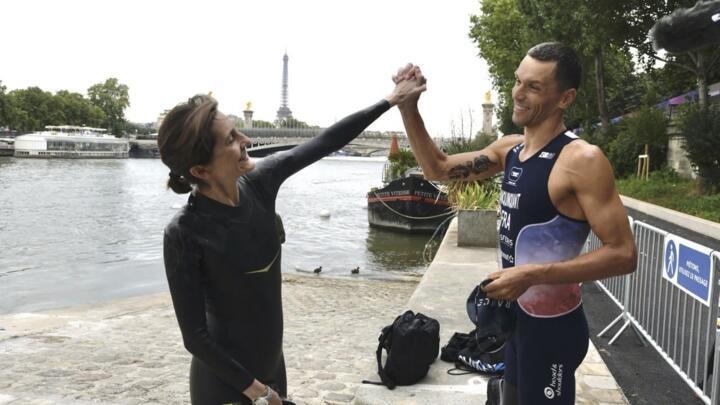 La ministre des Sports Amélie Oudéa-Castéra et le champion de triathlon Alexis Hanquinquant au moment de se baigner dans la Seine, le 13 juillet 2024 à paris