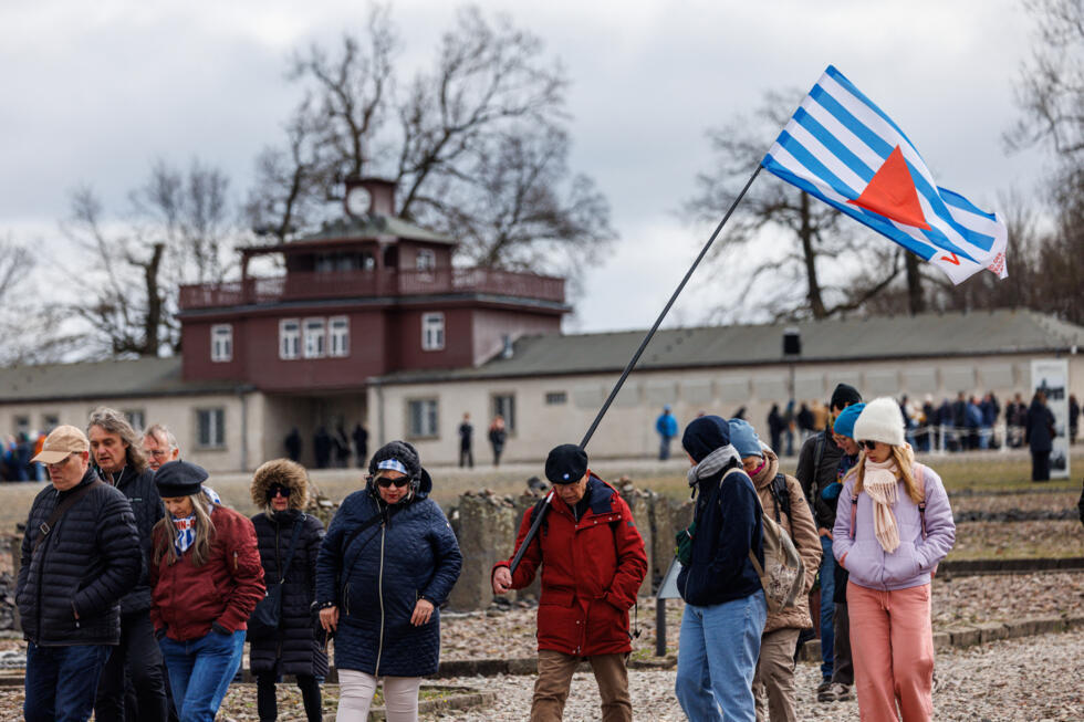 Des personnes devant la porte principale du camp nazi de Buchenwald avant une cérémonie de commémoration marquant le 80e anniversaire de la libération du camp de concentration nazi de Buchenwald, près de Weimar, dans l'est de l'Allemagne, le 6 avril 2025.