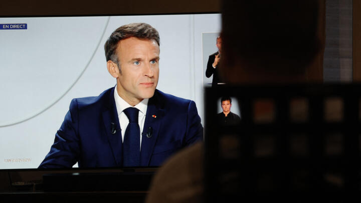 A man watches France's President Emmanuel Macron on a television screen in Paris during a live interview broadcasted on the French TV channel TF1's evening news and French public television news channel France 2 on September 24, 2023. 
