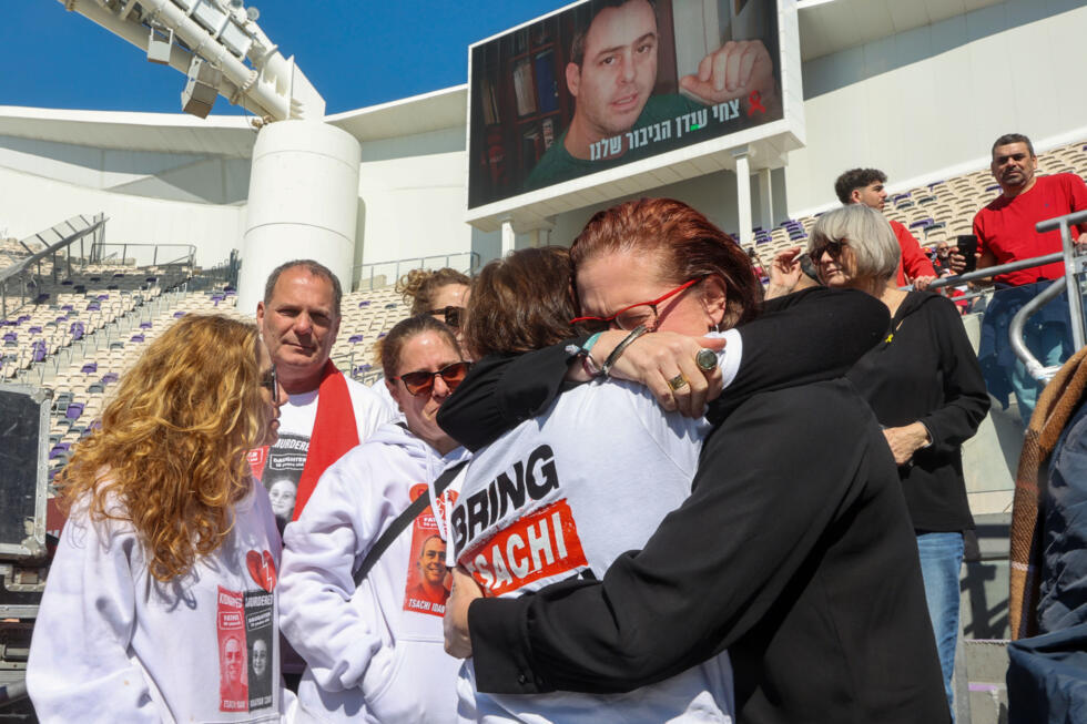 Une proche enlace la mère de l'ex-otage israélien Tsachi Idan lors d'une cérémonie publique à la mémoire d'Idan avant ses funérailles, au stade Bloomfield à Tel-Aviv, le 28 février 2025