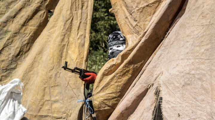 A Kurdish militant of the Kurdistan Workers' Party (PKK) aims his weapon from behind a barricade of concrete blocks during clashes with Turkish forces on September 28, 2015, at Bismil, in Diyarbakir.