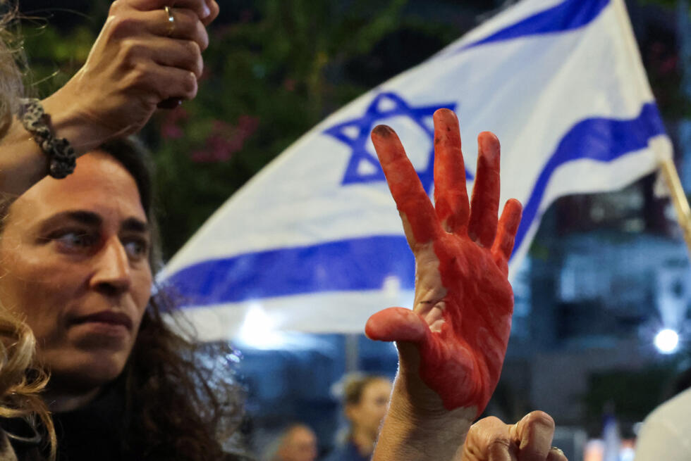 Les membres des familles et les amis des Israéliens retenus en otage à Gaza depuis octobre 2023, brandissent des drapeaux lors d'un rassemblement pour exiger leur libération, devant le ministère israélien de la Défense à Tel Aviv, le 8 mars 2025