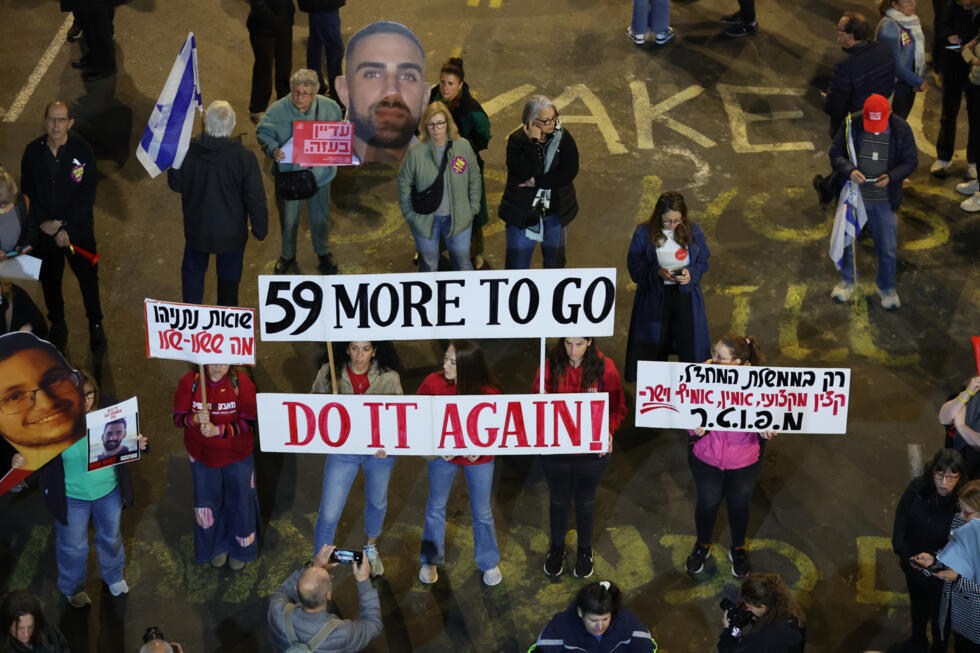 Des proches d'otages israéliens retenus à Gaza brandissent des pancartes appelant à la libération des otages, lors d'un rassemblement devant le ministère de la Défense à Tel-Aviv, le 8 mars 2025