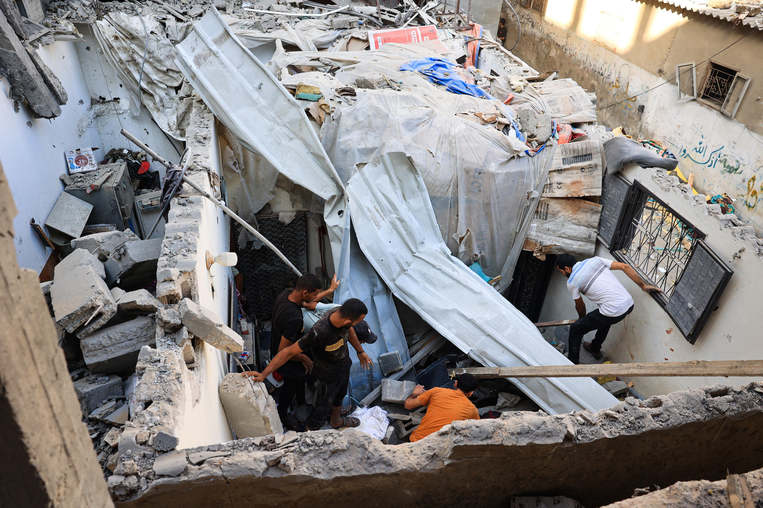 Des Palestiniens inspectent les dégâts causés par une frappe israélienne sur une maison dans le camp de réfugiés de Nousseirat, dans le centre de la bande de Gaza, le 6 juillet 2024.