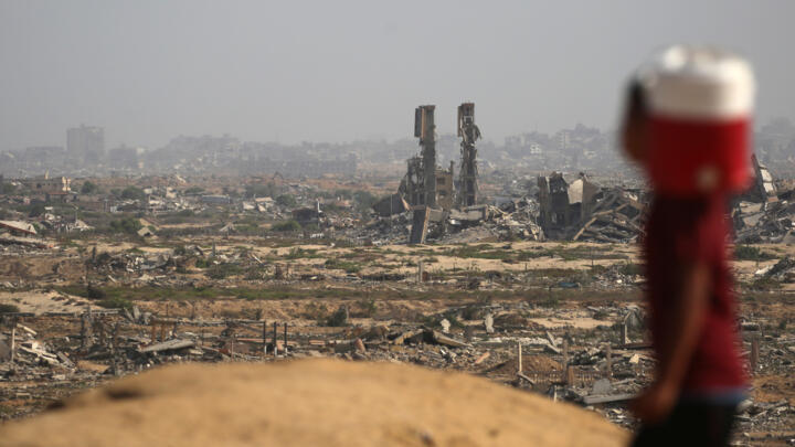 A Palestinian boy carries a container of water northwest of the Nuseirat refugee camp in the Gaza Strip on October 4, 2025.