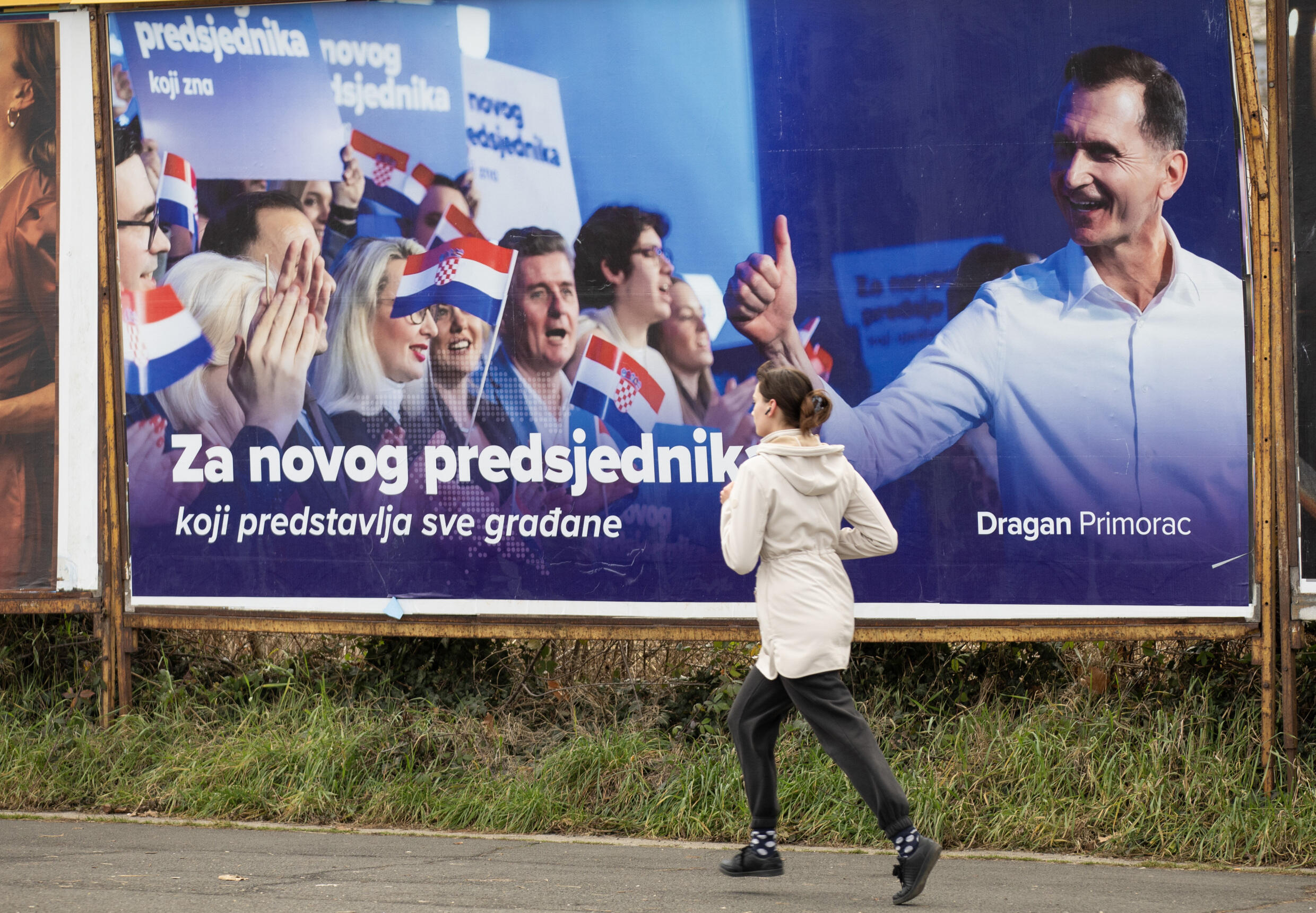 Une femme passe devant une affiche électorale du candidat à la présidentielle du HDZ, Dragan Primorac, le 9 janvier 2025