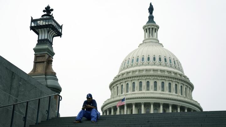A member of staff sits on steps close to the US Capitol, Washington, DC USA, 30 September 2025.