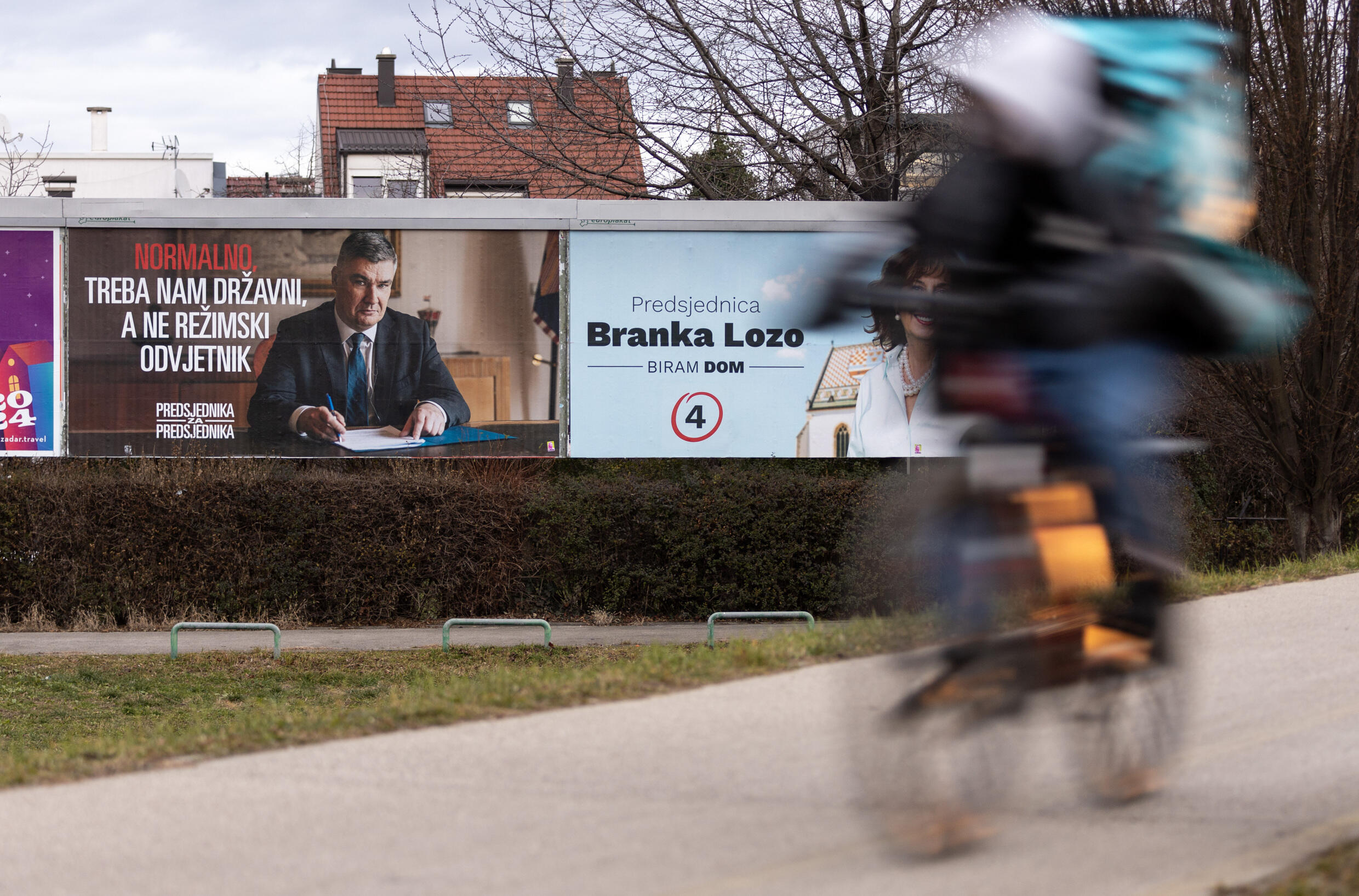 Un homme à vélo passe devant une affiche électorale du président croate sortant et candidat à la présidentielle, Zoran Milanovic, à Zagreb, le 9 janvier 2025