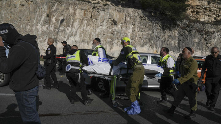 Israeli security forces and members of the Zaka rescue service carry a body from the scene of a shooting attack near the West Bank settlement of Maale Adumim on February 22, 2024.
