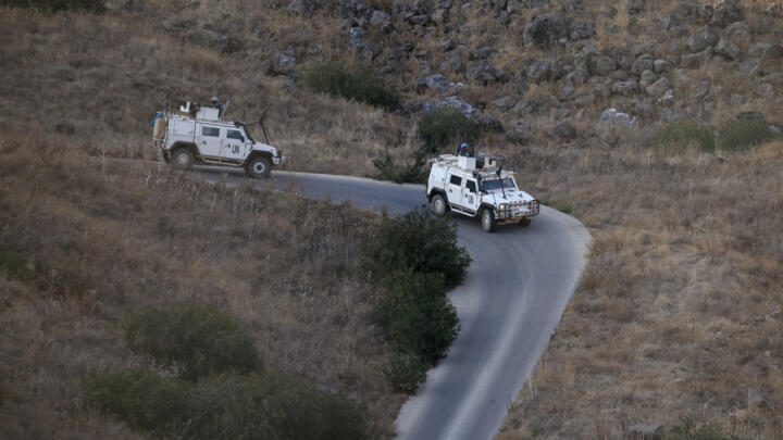 UN vehicles drive on the Lebanese side of the Israel-Lebanon border, as seen from northern Israel, on November 6, 2025.