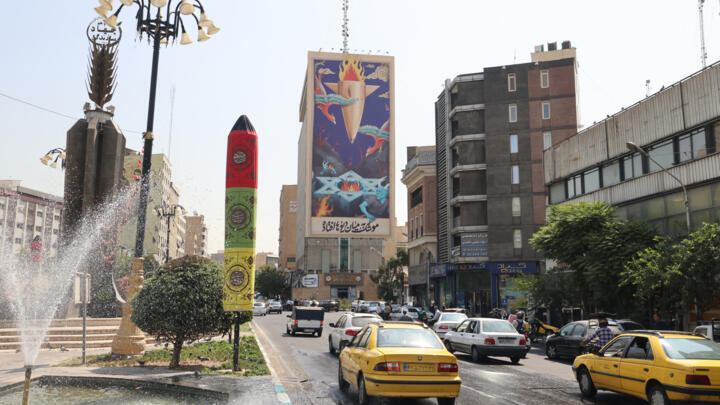 A billboard showing a painting of a missile falling on Israel with the slogan in Farsi: "The missile has fallen amid the demons", hangs above a main road in central Tehran on July 16, 2025.