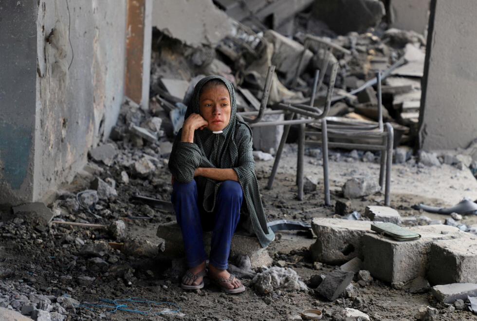 Una niña palestina sentada entre los escombros de una escuela de las Naciones Unidas donde se refugiaban personas desplazadas, tras ser alcanzada por los ataques israelíes durante la noche, en medio de una operación militar israelí, en el barrio de Zeitoun, en la ciudad de Gaza, el 1 de octubre de 2025.