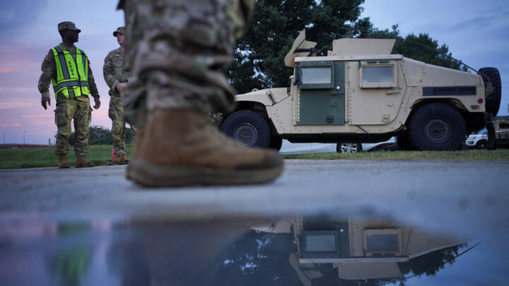 Members of the DC National guard and of the US military police stand near a military vehicle at the U.S. Park Police Anacostia Operations Facility in Washington, D.C., U.S., August 13, 2025.