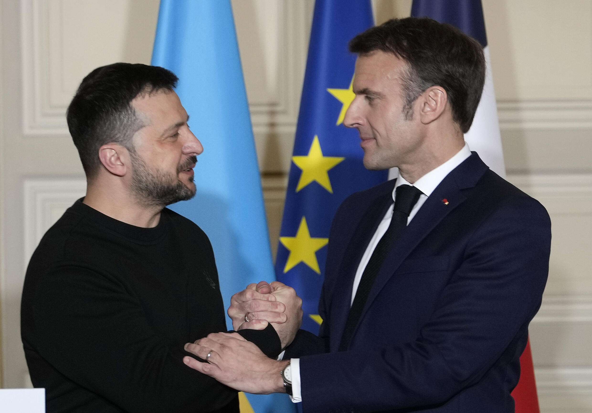 Le président français Emmanuel Macron (à droite) serre la main du président ukrainien Volodymyr Zelensky (à gauche) lors d'une conférence de presse à l'Élysée à Paris le 16 février 2024.
