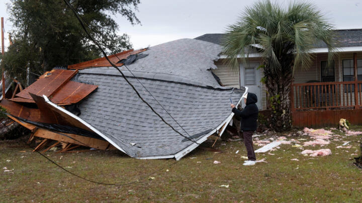 A resident checks a collapsed roof after a line of storms roared through the area of Perdido Key near Pensacola, Florida, U.S. January 9, 2024.