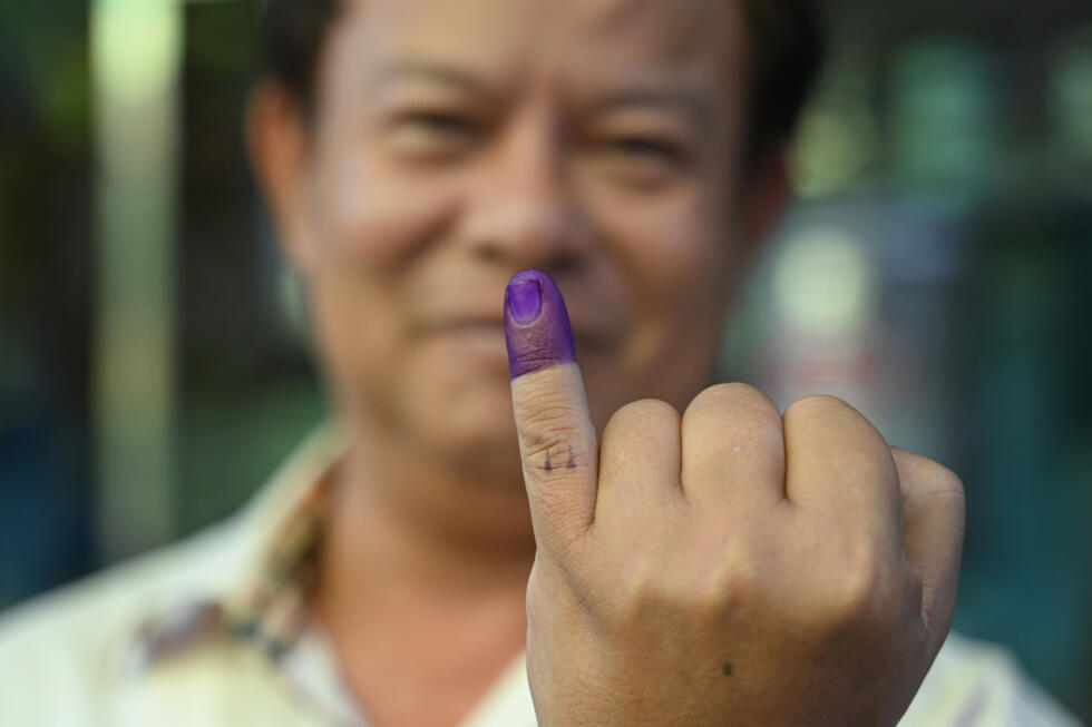 A voter shows an inked finger after casting a ballot