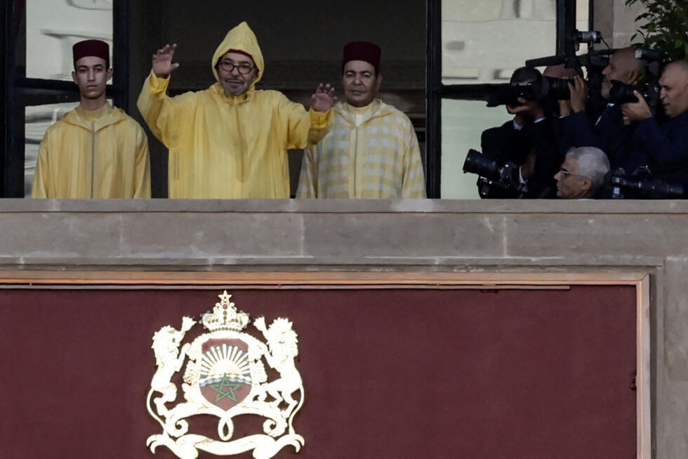 Morocco's King Mohammed VI (C), accompanied by his son, Crown Prince Moulay Hassan (L) appears on the balcony of the Parliament headquarters in Rabat on October 10, 2025.