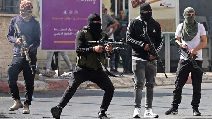 Palestinian armed militants fire at Israeli armoured vehicles in the occupied West Bank city of Jenin on July 3, 2023. 