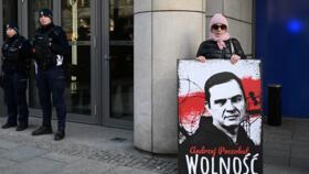 File photo of a demonstrator holding a poster to free Belarusian journalist Andrzej Poczobut taken in front of the European Parliament office in Warsaw, March 14, 2024