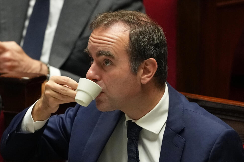 French Prime Minister Sébastien Lecornu has a coffee as he listens to speeches before a no-confidence vote at the National Assembly October 16, 2025.