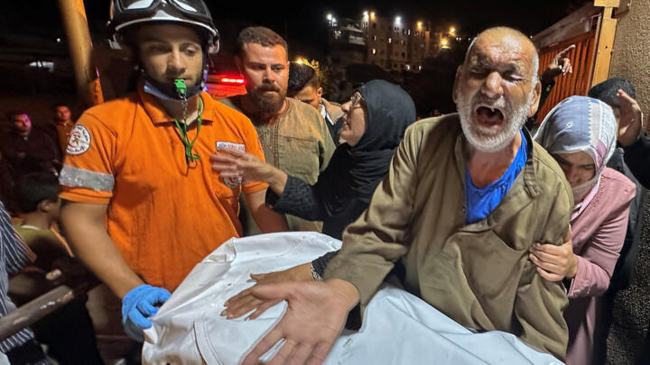A Palestinian man reacts next to the body of a man, who, according to medics, was killed in an Israeli strike earlier today, at Nasser Hospital in Khan Younis, southern Gaza Strip.