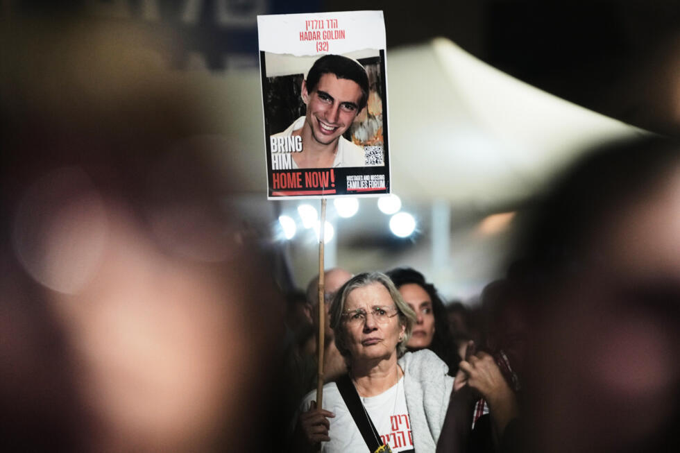 A woman holds a photo of Hadar Goldin, an Israeli soldier killed in 2014, at a rally in Tel Aviv, November 8, 2025.
