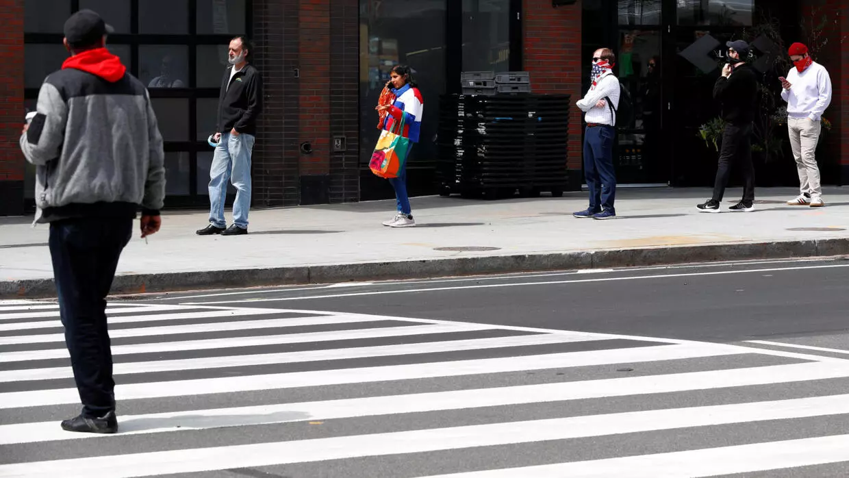 People wait in a socially distanced line outside a supermarket in New York City on April 14, 2020.