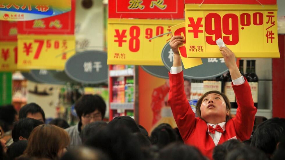 En esta foto tomada el domingo 20 de febrero de 2011, un trabajador pone una lista de precios mientras los clientes compran comestibles en un nuevo supermercado en Chengdu, en la provincia suroccidental china de Sichuan. La semana pasada, China ordenó a sus bancos que retuvieran más dinero como reservas, en una nueva medida para frenar los préstamos y enfriar un aumento en la inflación.