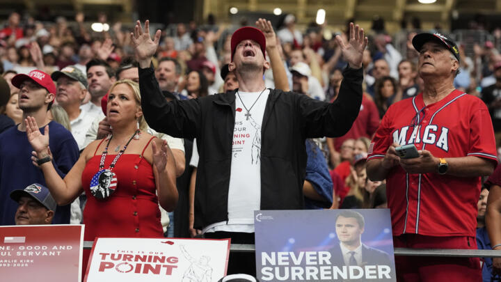 A man listens during a worship song at a memorial for the late conservative activist Charlie Kirk at State Farm Stadium in Glendale, Arizona, on September 21, 2025.