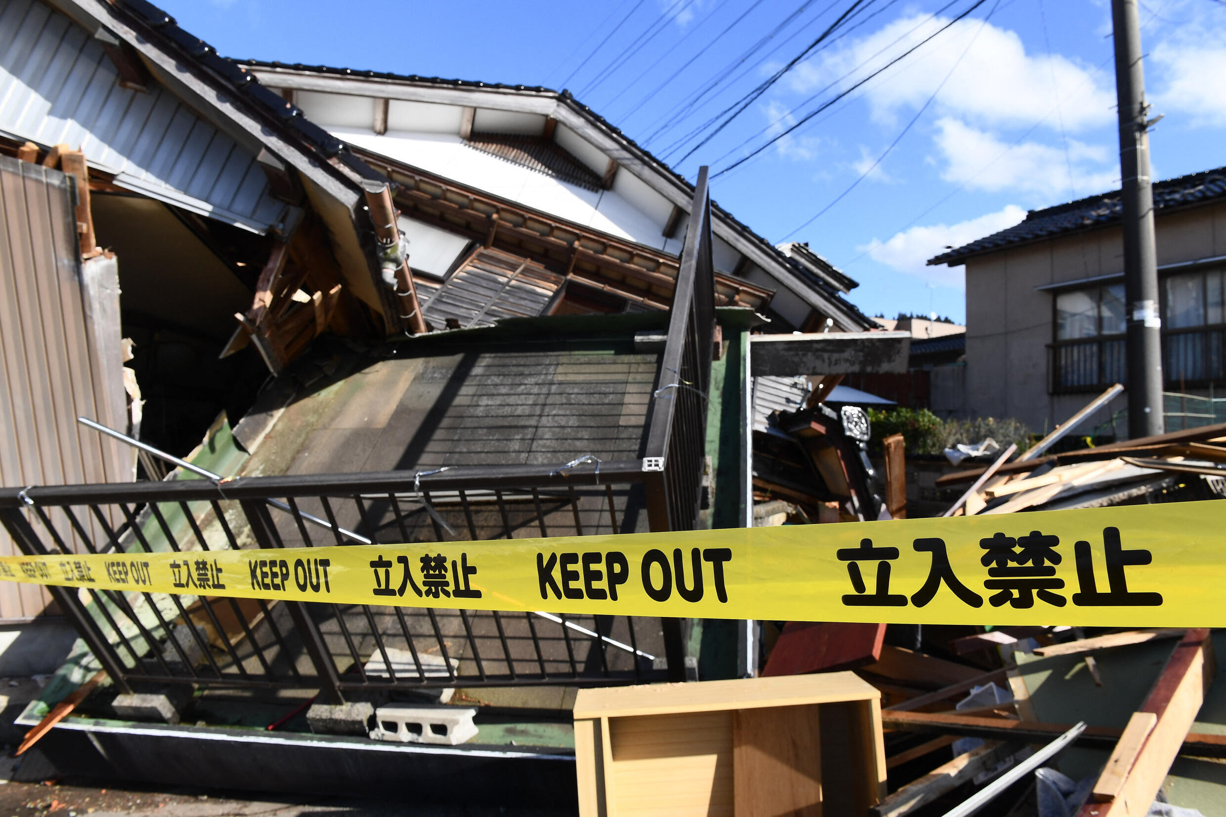 La police a barré l'accès à des maisons effondrées dans la ville d'Anamizu, dans le département d'Ishikawa, le 4 janvier 2024, après qu'un séisme majeur a frappé la région de Noto, le jour du Nouvel A