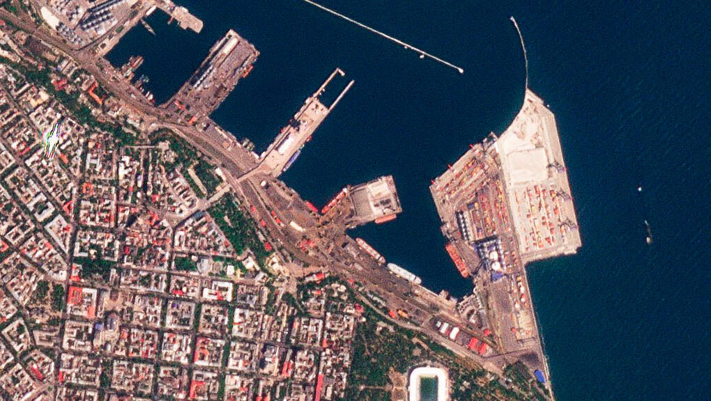 Esta foto satelital proporcionada por Planet Labs PBC muestra el buque de carga ‘Razoni’ con bandera de Sierra Leona, ubicado en el centro con mástiles blancos, atracado en el puerto de Odessa, Ucrania, el domingo 31 de julio de 2022.