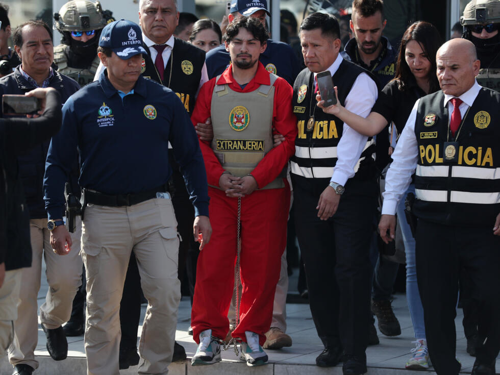 Matías Agustín Ozorio (c), de nacionalidad argentina, es trasladado por integrantes de la Policía Nacional de Perú (PNP) y de Interpol para ser entregado a la Policía Argentina este jueves, en la Base Aérea de Policía Aérea de Perú en Lima (Perú).