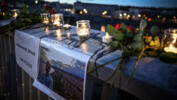Candles and flowers displayed during a tribute to Mohammad Moradi, an Iranian man who killed himself after jumping into the Rhone river to raise awareness about the situation of the Iranian people, December 27, 2022.
