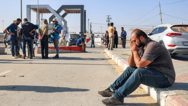 A man sits near the gate to the Rafah border crossing with Egypt in the south of the Gaza Strip on November 3, 2023.