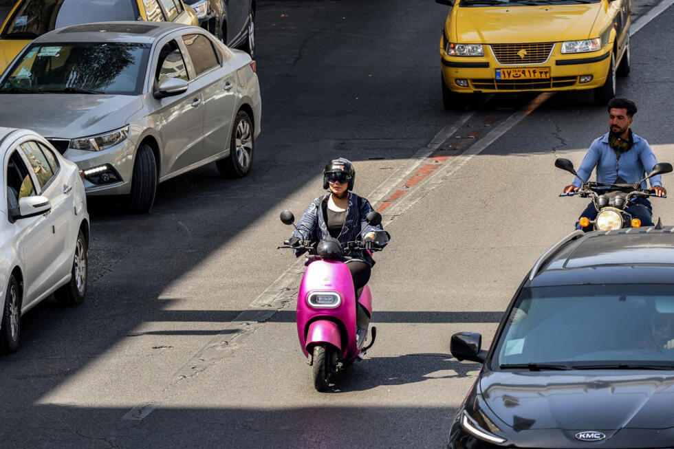 A woman rides a scooter in Tehran on September 15, 2025.