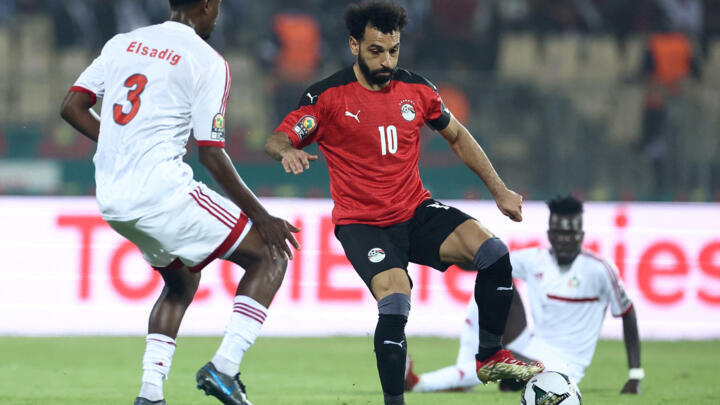 Egypt's forward Mohamed Salah (C) challenges Sudan's defender Elsadig Hassan (L) during the Group D Africa Cup of Nations match between Egypt and Sudan at Stade Ahmadou Ahidjo in Yaounde, Cameroon, on January 19, 2022.