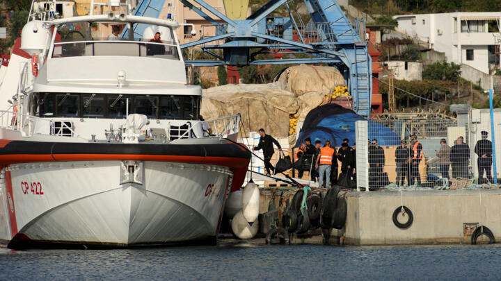 Un groupe de migrants embarque sur un navire des garde-côtes italiens dans le port de Shengjin, en Albanie, le 19 octobre 2024.